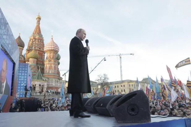 Rusya Devlet Başkanı Vladimir Putin, Moskova'nın merkezindeki Kremlin Duvarı önünde düzenlenen miting sırasında konuşma yaparken (AFP)