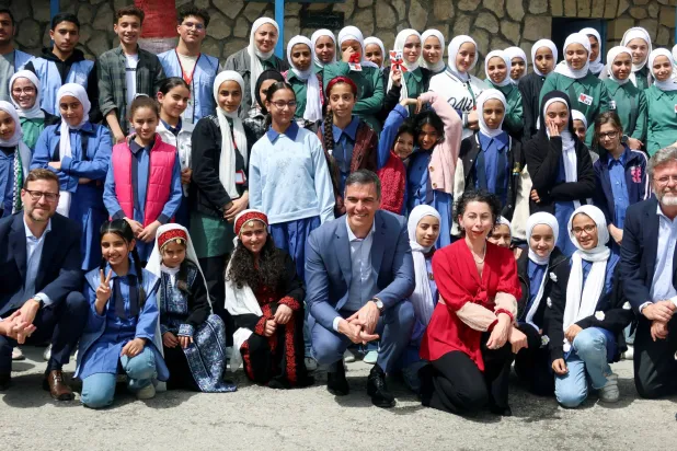 رئيس الوزراء الإسباني بيدرو سانشيز مع تلاميذ مدرسة تابعة لـ«أونروا» في مخيم جبل الحسين للاجئين الفلسطينيين في عمّان الثلاثاء (رويترز)