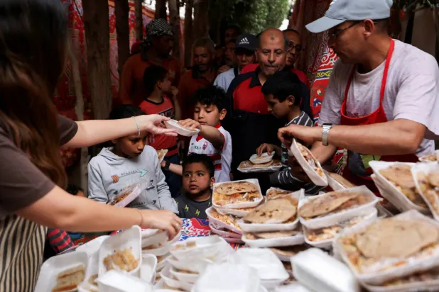 متطوعون يقومون بإعداد وجبات ساخنة للصائمين خلال شهر رمضان المبارك وسط الأزمة الاقتصادية (رويترز)