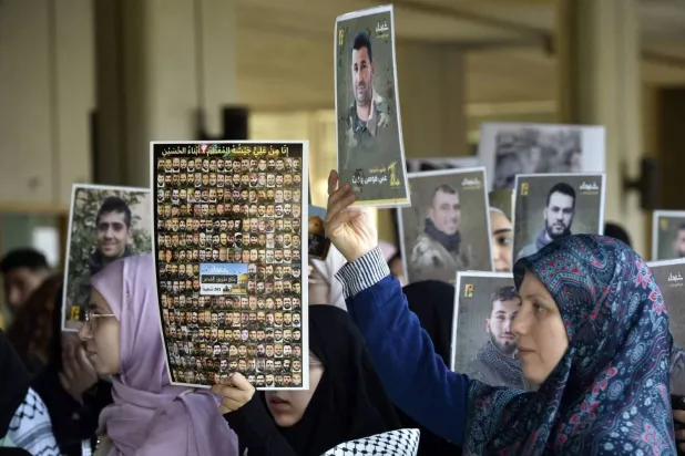 Students supporting Hezbollah at the Lebanese University carry pictures of members killed in the battle against Israel. (AP)