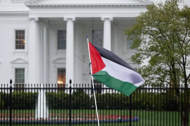 متظاهرون يلوّحون بالعَلم الفلسطيني خلال المطالبة بوقف إطلاق النار في غزة أمام البيت الأبيض بواشنطن (أ.ف.ب)