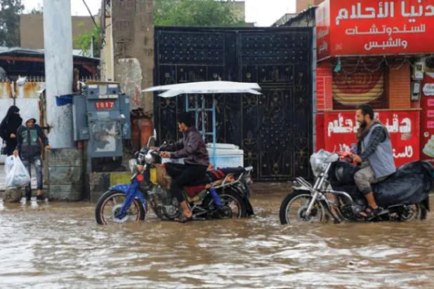 Yemenis ride motorcycles through a flooded street following heavy rain in Sanaa, Yemen (AFP) 