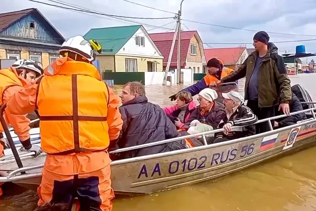رجال الإنقاذ يقومون بإجلاء السكان من منطقة الفيضانات في أورسك بأورينبورغ (إ.ب.أ)