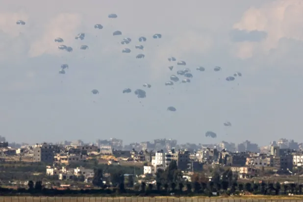 مساعدات يجري إنزالها بمظلات فوق قطاع غزة الثلاثاء (رويترز)