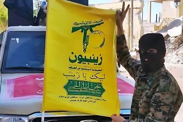 مقاتلون شيعة باكستانيون يحملون راية كتيبة «زينبيون»... (متداولة)