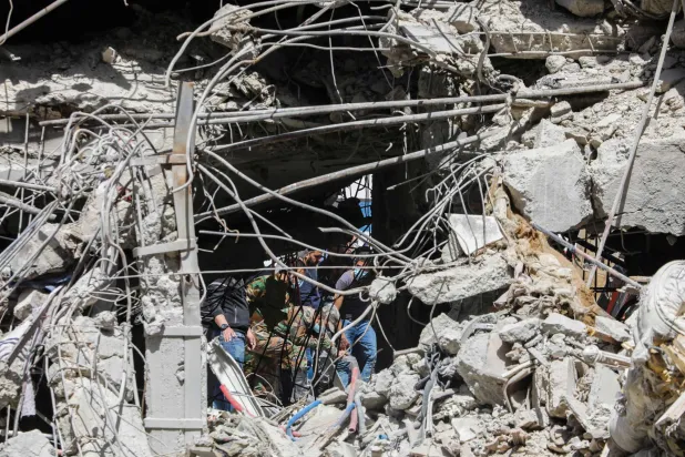 عمال إنقاذ يبحثون بين أنقاض مبنى ملحق بالسفارة الإيرانية بعد يوم من غارة جوية استهدفته في دمشق... 2 أبريل 2024 (أ.ف.ب)