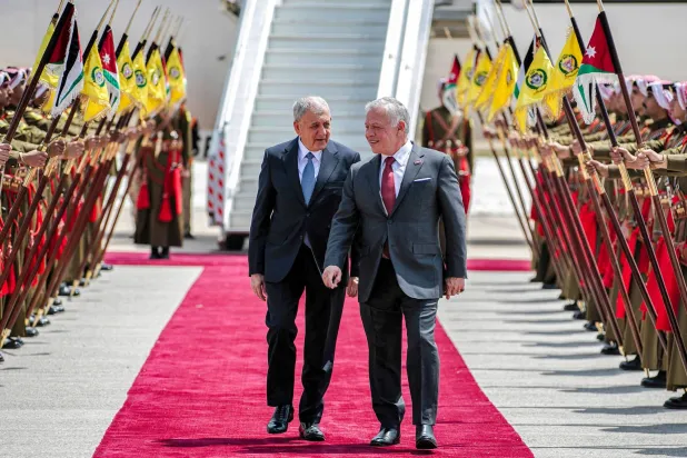 الملك عبد الله الثاني مستقبلاً الرئيس العراقي في مطار ماركا الاثنين (الديوان الملكي الأردني - أ.ف.ب)