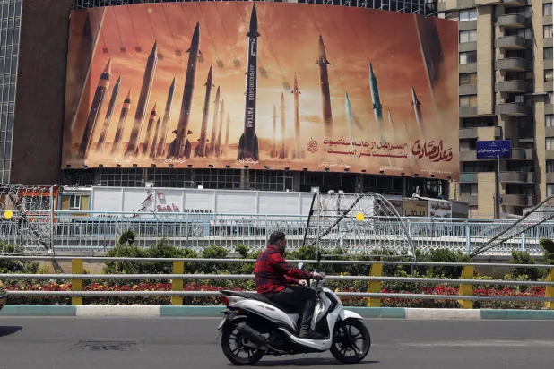 ملصق ضخم وسط طهران محتفياً بصواريخ عملية «الوعد الصادق» الإيرانية (إ.ب.أ)