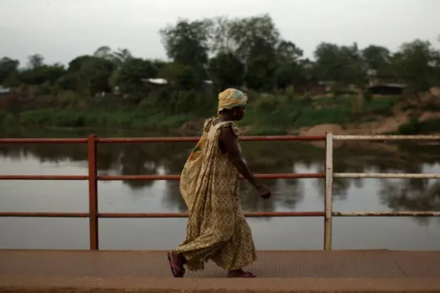امرأة تعبر جسراً فوق نهر مبوكو في بانغي (أرشيفية- رويترز)