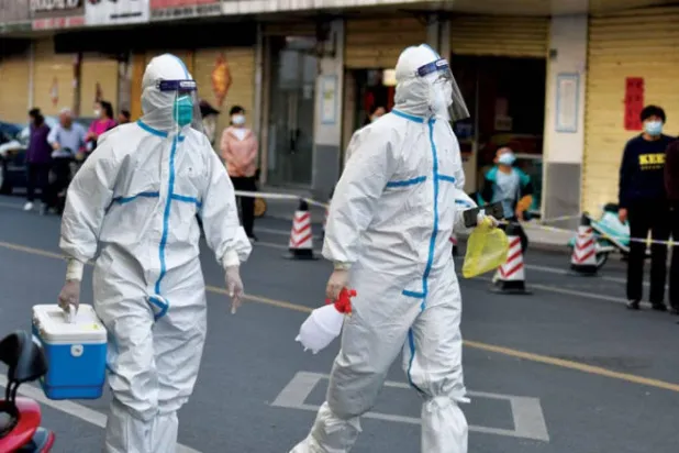 ممرضان بملابس واقية في إحدى المدن الصينية (أرشيفية - د.ب.أ)