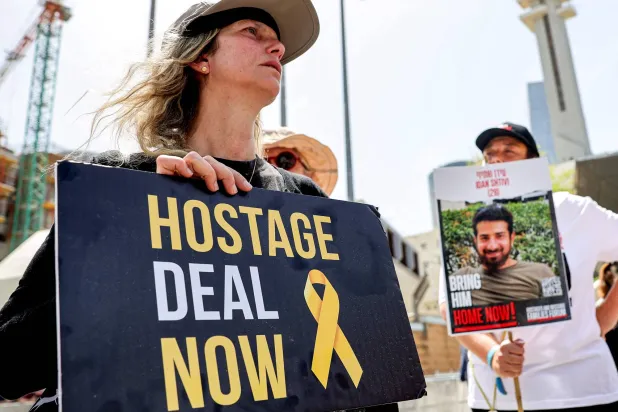 أقارب الرهائن الإسرائيليين المحتجزين في غزة منذ هجمات 7 أكتوبر يحتجون خارج مقر وزارة الدفاع في تل أبيب الخميس (أ.ف.ب)