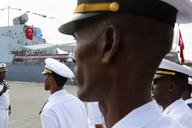 قوات عسكرية صومالية تقف بالقرب من سفينة البحرية التركية التي رست في ميناء مقديشو بعد توقيع اتفاقية دفاعية واقتصادية بين الصومال وتركيا في مقديشو الثلاثاء (رويترز)