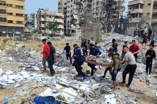 فلسطينيون يتفقدون منزلاً مدمراً بعد قصف إسرائيلي على مدينة غزة (د.ب.أ)