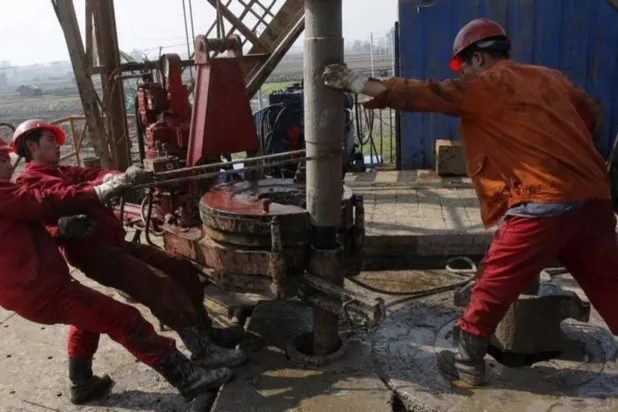 عمال يعملون في حقل نفطي في إقليم هوبي الصيني (رويترز)