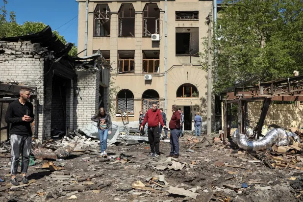 سكان محليون يتفقدون الأضرار في موقع تعرّض لضربة صاروخية روسية في خاركيف بأوكرانيا في 30 أبريل 2024 (رويترز)
