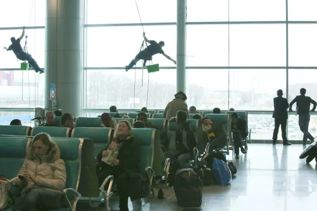 
عمال يستخدمون الحبال الهوائية لتنظيف نوافذ مطار دوموديدوفو بموسكو الذي يملكه رجل الأعمال الروسي دميتري كامينشيك (غيتي)