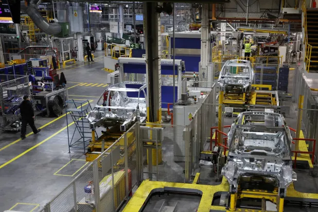 موظفون يعملون على خط الإنتاج في مصنع «هالوود» التابع لشركة «جاكوار لاند روفر» في ليفربول ببريطانيا (رويترز)