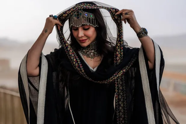 سيدة ترتدي زياً تراثياً أثناء حضورها فعاليات السباق في العلا (الشرق الأوسط)