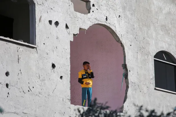 طفل فلسطيني يقف داخل منزل في رفح تضرر جراء الغارات الإسرائيلية على قطاع غزة (رويترز)