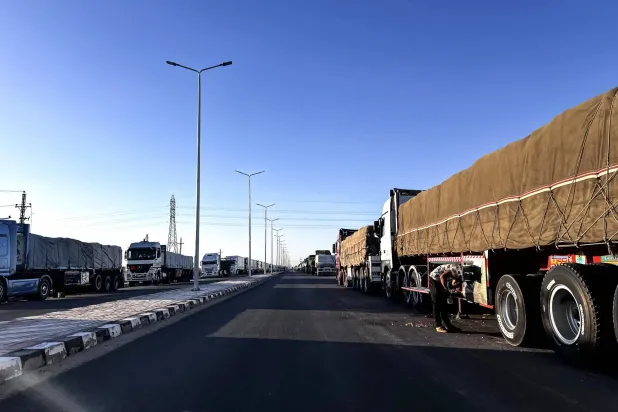 شاحنات تحمل مساعدات إنسانية إلى غزة تصطف منذ أمس في انتظار التحرك نحو معبر رفح الحدودي من العريش (إ.ب.أ)