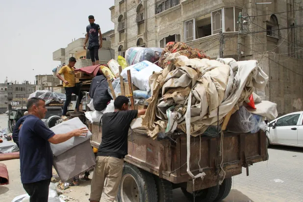 فلسطينيون يقومون بتحميل ممتلكاتهم بينما يستعدون للإخلاء بعد أن شنت القوات الإسرائيلية عملية برية وجوية في الجزء الشرقي من رفح (رويترز)