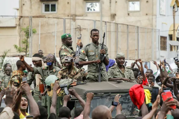 حشود تهتف أثناء عرض لجنود ماليين في شوارع باماكو عاصمة مالي، في أغسطس 2020 (أ.ف.ب)