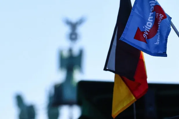 علم حزب «البديل لألمانيا» مرفوع خلال مظاهرة للمزارعين اعتراضاً على سياسات الحكومة بالقرب من بوابة براندبيرغ (إ.ب.أ)