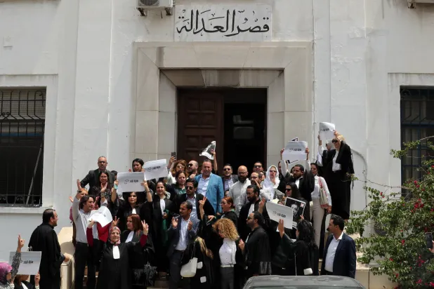 محامون تونسيون يرفعون لافتات احتجاجية يوم الاثنين اعتراضاً على اعتقال زميلتهم (إ.ب.أ)