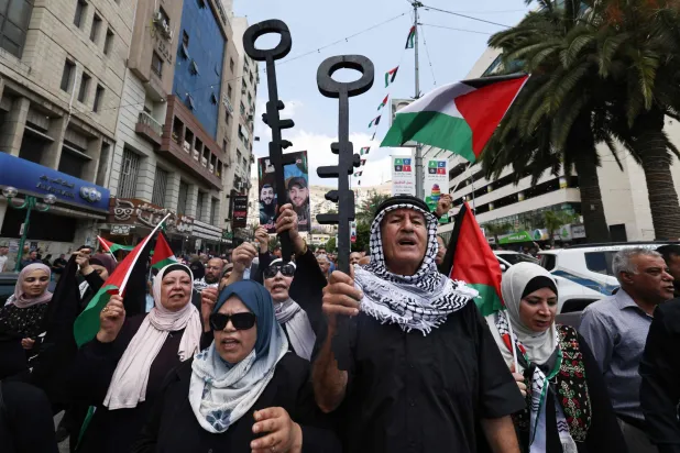 فلسطينيون يحملون مفاتيح رمزية خلال مسيرة في مدينة رام الله بالضفة الغربية الأربعاء لإحياء الذكرى السادسة والسبعين لـ«النكبة» التي أدَّت إلى نزوح مئات الآلاف من الفلسطينيين عام 1948 (أ.ف.ب)