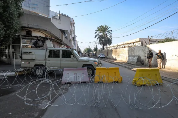 عناصر أمن في نقطة تفتيش بالكاظمية قرب معسكر «الشعبة الخامسة» (أرشيفية - أ.ف.ب)