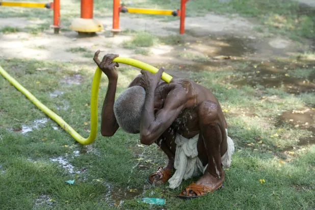 رجل يبرد جسده من درجة الحرارة الشديدة في الهند (أ.ب)