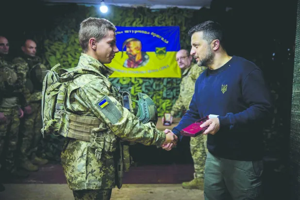 
أرشيفية للرئيس الأوكراني فولوديمير زيلينسكي يسلم جندياً وساماً (أ.ف.ب)