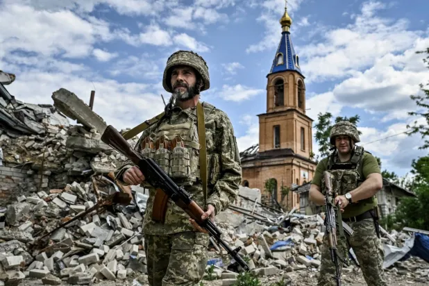 Ukrayna'nın Zaporojya kentindeki enkazın ortasında iki Ukraynalı asker (Reuters)