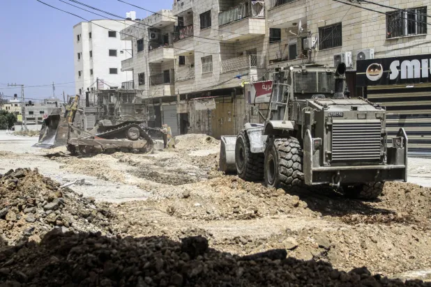 جرافة إسرائيلية تدمر البنية التحتية لمخيم جنين شمال الضفة الغربية خلال عملية عسكرية الثلاثاء (د.ب.أ)