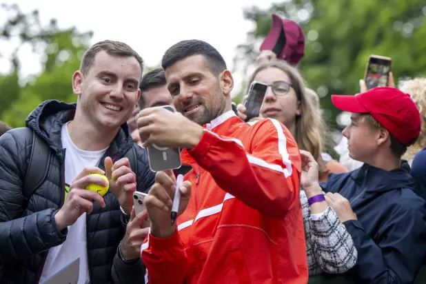 نوفاك مع مشجعين ومشجعات خلال التحضير لرولان غاروس (إ.ب.أ)