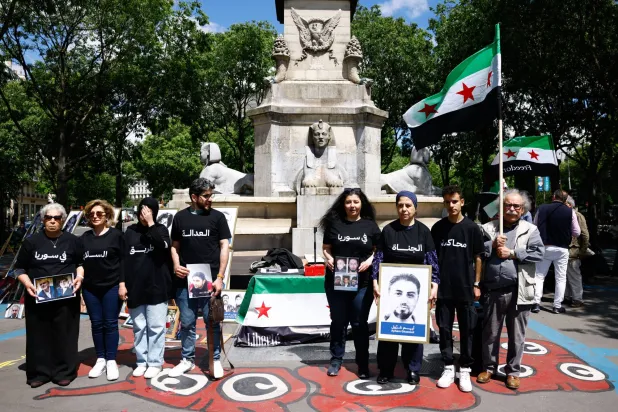 تجمع لناشطين سوريين في باريس بالتزامن مع محاكمة المسؤولين الأمنيين الثلاثة أمام محكمة فرنسية (أرشيف - إ.ب.أ)