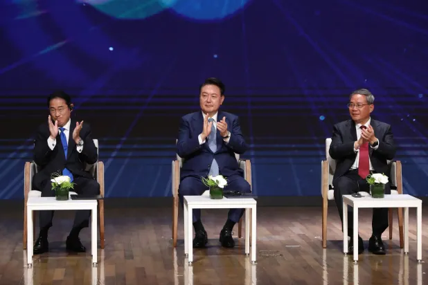 (من اليمين) الرئيس الكوري الجنوبي يون سيوك-يول ورئيس الوزراء الصيني لي تشيانج ورئيس الوزراء الياباني فوميو كيشيدا في سيول (إ.ب.أ)