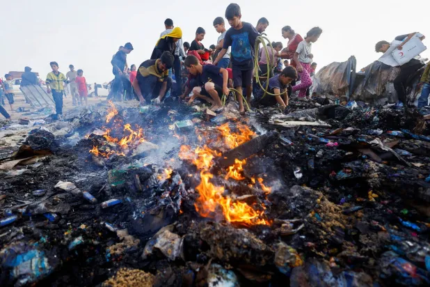 أطفال فلسطينيون وسط بقايا خيام النازحين التي تعرضت لقصف إسرائيلي في رفح (رويترز)