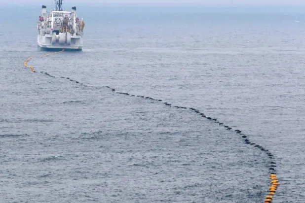 Technicians lay a submarine cable. (Reuters) 