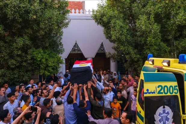 مواطنون يحملون نعش الجندي المصري الذي قُتل خلال إطلاق نار في معبر رفح (إ.ب.أ)