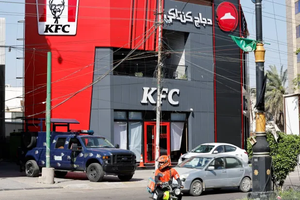 الشرطة العراقية تحرس فرعاً لمطعم «كنتاكي - KFC» في بغداد تعرض لهجوم الاثنين (رويترز)