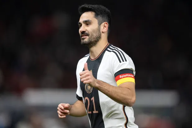 إلكاي غوندوغان مرتدياً شارة القيادة بالعلم الألماني خلال مواجهة سابقة (د.ب.أ)