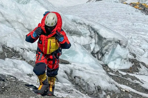 أحد المتسلقين في طريقه إلى قمة جبل إيفرست رغم المخاطر (أ.ف.ب)