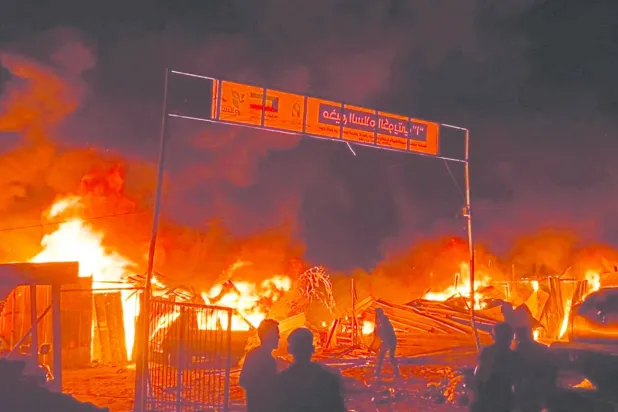 اشتعال النيران وسط خيام النازحين التي تعرضت لقصف إسرائيلي في رفح (رويترز)