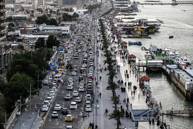 مركبات تمر أمام الواجهة البحرية لنهر شط العرب في البصرة جنوب العراق مطلع مايو الحالي (أ.ف.ب)