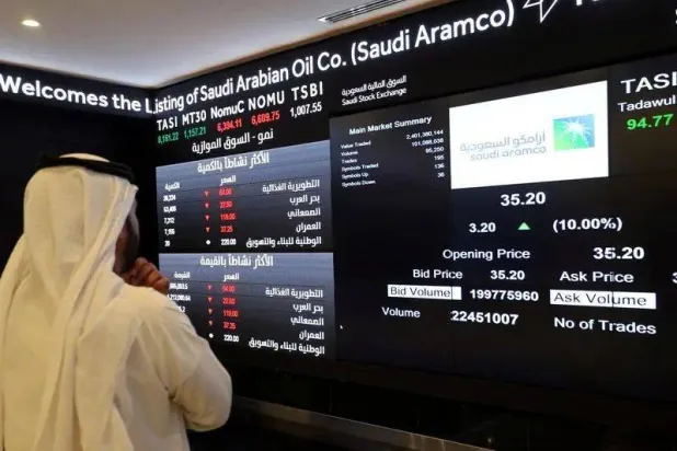 مستثمر يراقب شاشة تعرض معلومات الأسهم في السوق المالية السعودية بعد الطرح الأولي لـ«أرامكو» بتاريخ 11 ديسمبر 2019 (رويترز)