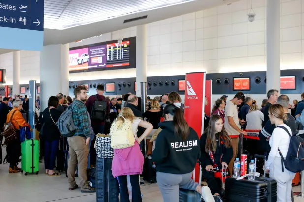 أناس يصطفون في مطار بيرث بأستراليا (إ.ب.أ)