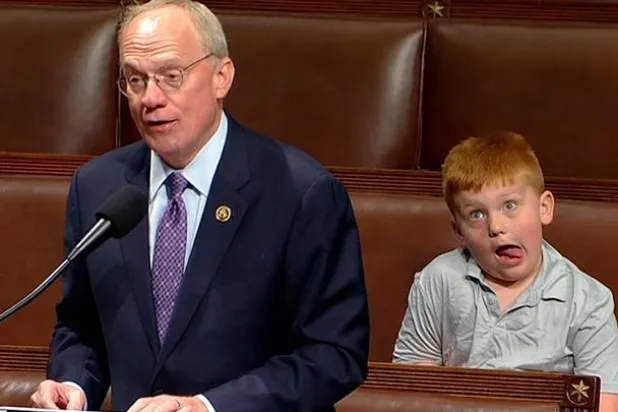 روز الصغير يخرج لسانه ويقوم بإيماءات بوجهه بينما كان يجلس خلف والده الذي يلقي خطابه في قاعة مجلس النواب الأميركي