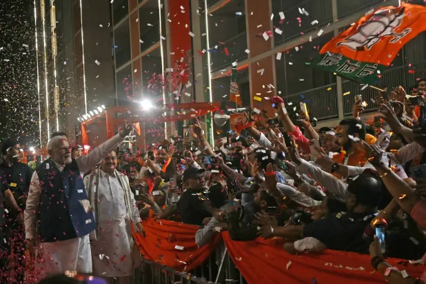 رئيس الوزراء الهندي ناريندرا مودي يلوح لأنصاره في مقر حزبه «بهاراتيا جاناتا» احتفالاً بالفوز في الانتخابات (أ.ف.ب)