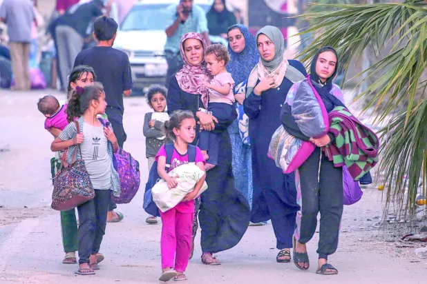 İsrail'in yeni bir askeri operasyon başlatmasının ardından, Gazze Şeridi'nin orta kesimindeki el-Bureyc Mülteci Kampı’ndan ayrılan Filistinliler (EPA)